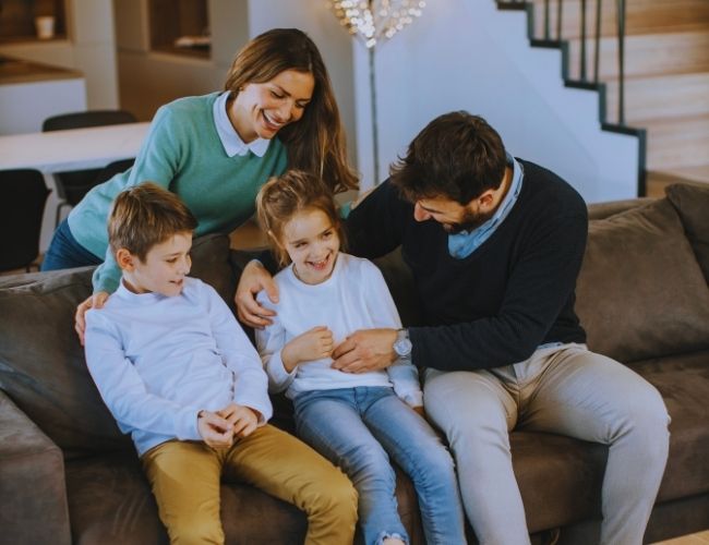 Financial Planner Glenwood - Happy family sitting on a sofa interacting